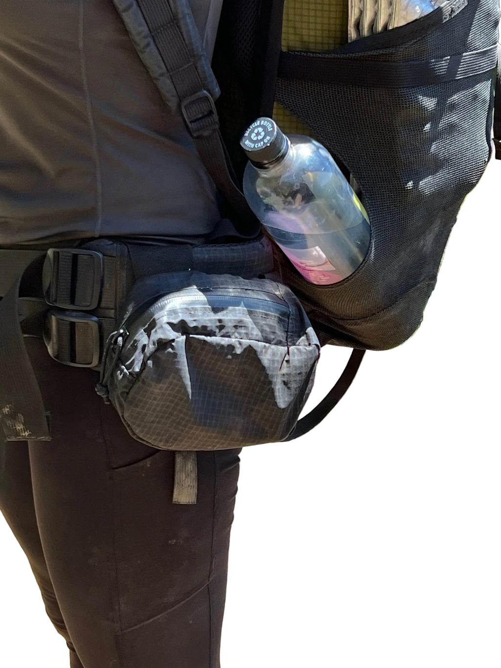 Person wearing a fanny pack with a water bottle and pouch in an outdoor setting