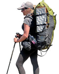 Person hiking with a large backpack, walking stick, and water bottle on a gray background